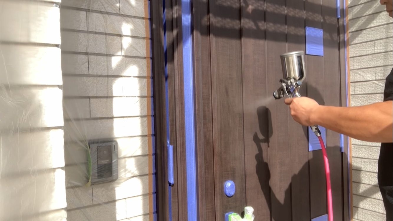 姫路市でアルミ製玄関ドアの塗装を代表の藤原健太が心を込めて塗装している・藤原ペイント