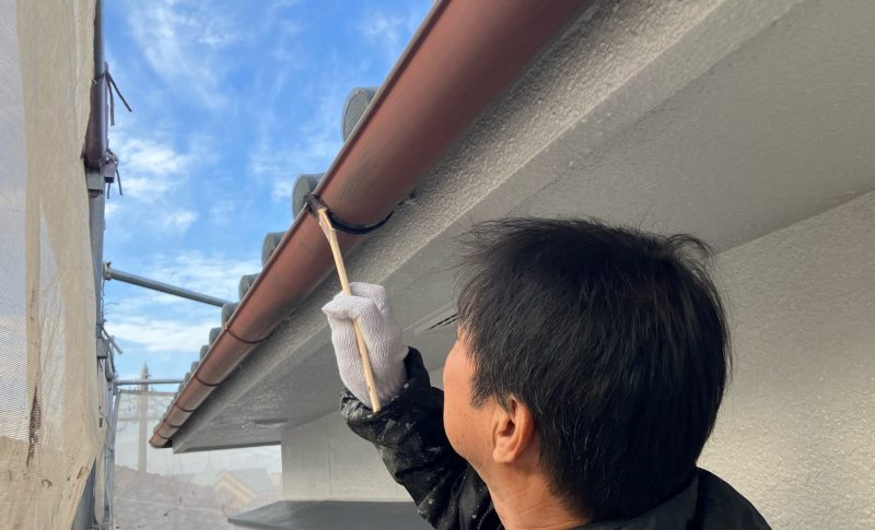 姫路市周辺で雨樋をフッ素樹脂塗料で塗装中の職人、藤原一也・藤原ペイント